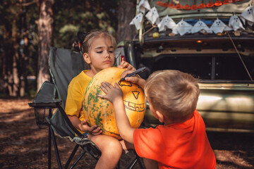 Safe distant Halloween celebration. Kids preparing decoration for party in the trunk of car