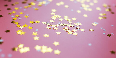 Stars and snowflakes on a pink background, from above