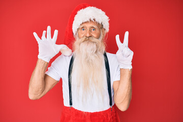 Fototapeta na wymiar Old senior man with grey hair and long beard wearing white t-shirt and santa claus costume showing and pointing up with fingers number seven while smiling confident and happy.