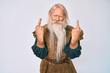 Old senior man with grey hair and long beard wearing viking traditional costume showing middle finger doing fuck you bad expression, provocation and rude attitude. screaming excited