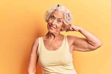 Senior grey-haired woman wearing casual clothes smiling pointing to head with one finger, great idea or thought, good memory