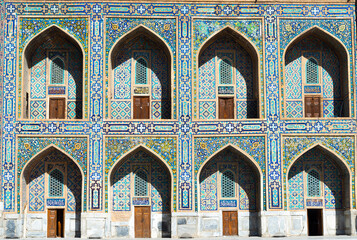 Fototapeta na wymiar Pishtaq and spandrel with detailed mosaic at Samarkand, Uzbekistan. Islamic architecture with multiple iwans and colorful ceramic tiles. Tilya Kori Madrasah facade.