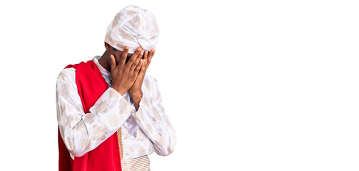 African handsome man wearing tradition sherwani saree clothes with sad expression covering face...