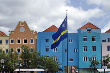 Flag in front of colorful buildings on Curacao