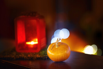 Autumn composition with red lantern and small yellow pumpkin. Decoration for Halloween. Halloween holiday concept with pumpkin and candles over dark night background