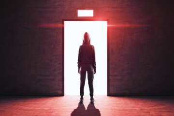 Hacker stands in front of an open elevator door from whicha red light emanates.