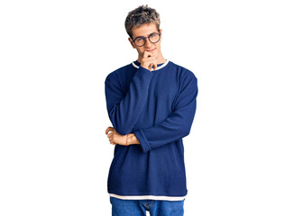 Young handsome man wearing casual clothes and glasses looking confident at the camera with smile with crossed arms and hand raised on chin. thinking positive.