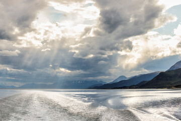 Sunbeams on the water in the Beagle Channel with mountains in the background