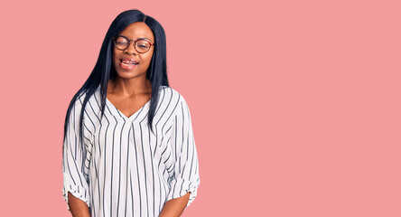 Young african american woman wearing casual clothes and glasses winking looking at the camera with...