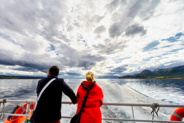 Adult couple contemplate the landscape of the Beagle Channel from the stern of a ferry boat during...