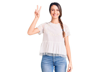 Obraz na płótnie Canvas Young beautiful girl wearing casual t shirt smiling with happy face winking at the camera doing victory sign. number two.