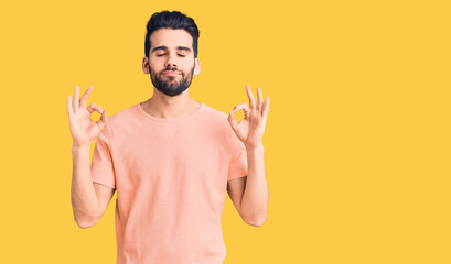 Young handsome man with beard wearing casual t-shirt relax and smiling with eyes closed doing meditation gesture with fingers. yoga concept.