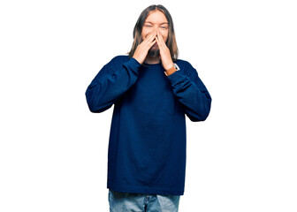 Handsome caucasian man with long hair wearing casual winter sweater laughing and embarrassed giggle...