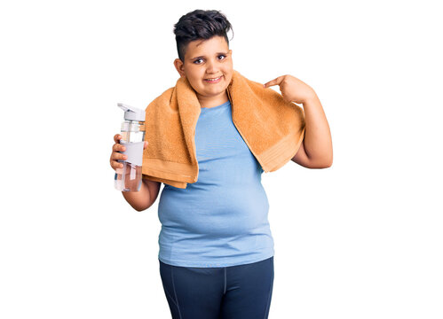 Little boy kid wearing sportswear drinking bottle of water pointing finger to one self smiling happy and proud
