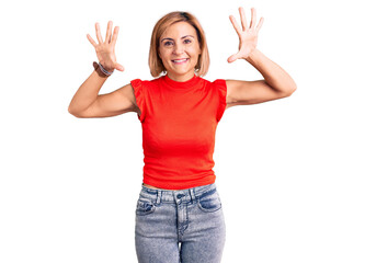 Young blonde woman wearing casual clothes showing and pointing up with fingers number ten while smiling confident and happy.