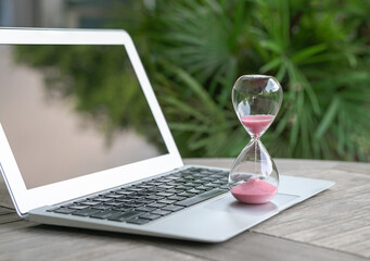Hourglass on top of computer laptop