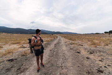 Fototapeta premium Chico joven andando por sendero y tomando fotografías