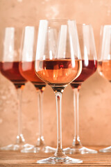 Rose wine glasses assortment on wine tasting. Degustation different varieties, colors and shades of pink wine concept. Beige background