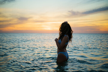 Chica veraniega morena en la playa naturaleza cañas de bambu con skateboard y bikini disfrutando de la hora dorada del atardecer