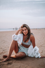 Chica veraniega morena en la playa naturaleza cañas de bambu con skateboard y bikini disfrutando de la hora dorada del atardecer