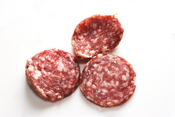 Three pieces of dry-cured sausage.