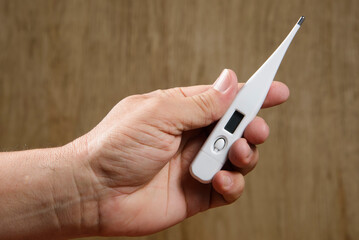 hand holding digital thermometer.