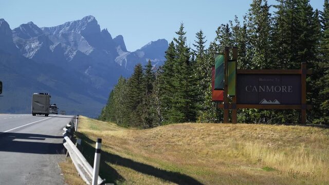 Establishing shot showing welcome sign on Trans-Canada Highway at the entrance of Canmore town during summer in Alberta, Canada.