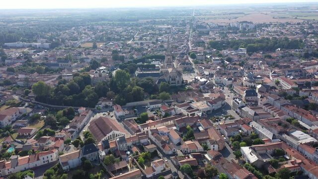 View from drone of houses and ancient Roman Catholic Cathedral of Lucon town at summer day, France
