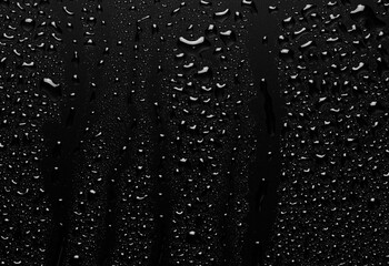 Water droplets on a black background. Water droplets on a background of water drops.