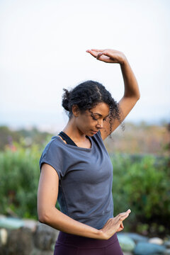 Black woman practicing yoga outdoors in garden