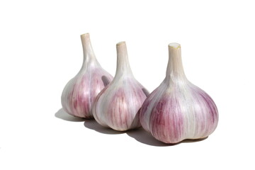 Three heads of garlic stand on a white background