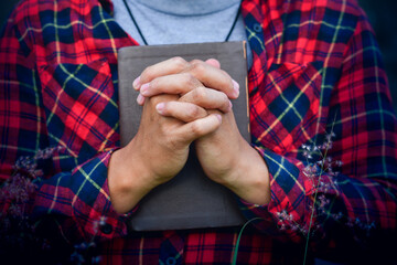 A Man praying holding a Holy Bible. christian concept.