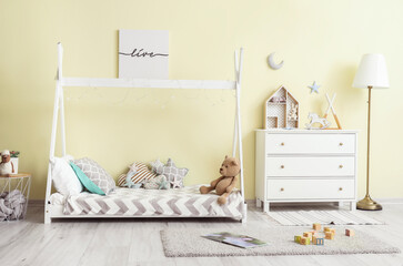 Interior of modern children's room with comfortable bed and chest of drawers