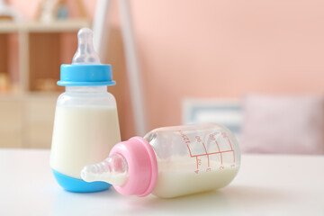 Bottles of milk for baby on table in room
