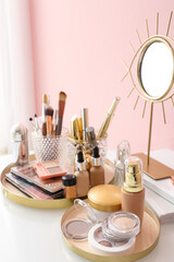 Set of decorative cosmetics and mirror on dressing table