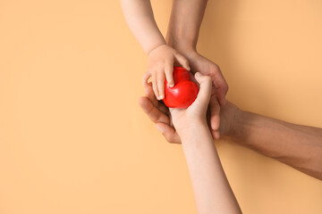 Hands of family with heart on color background