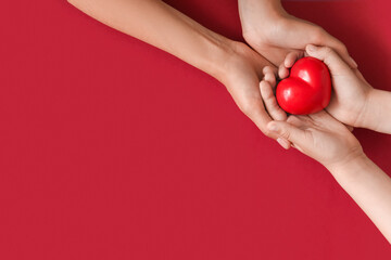 Hands of family with heart on color background