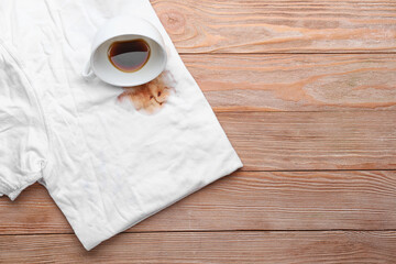 Dirty clothes with cup of coffee on wooden background
