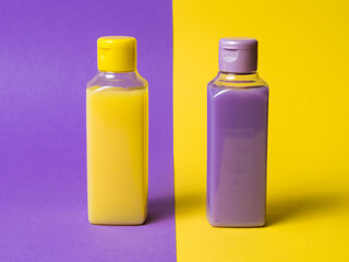 Two plastic bottles with a yellow and lilac product on a two-color background.