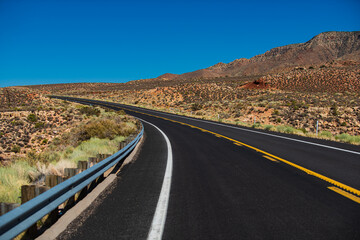 Landscape with orange rocks, sky with clouds and asphalt road in summer. American roadtrip.