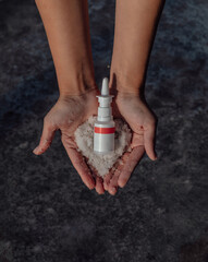 Hands with a bottle of medication. Treatment colds via a nasal spray. Top view