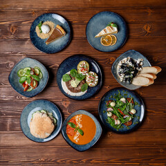Assortment of european meals, placed in a circle, on a wooden table, above view
