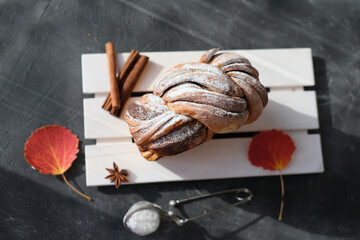 artisan sourdough cinnamon swirl bread on wooden rack. top view of autumn traditional sweet loaf bread with cinnamon and powdered sugar. spicy fresh baked bread. fall season pastry.