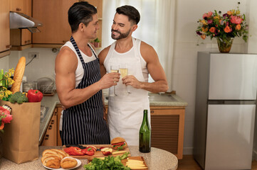 Happy LGBT couples cook in the home family kitchen together with love, smile and romantic moment with a champagne toast