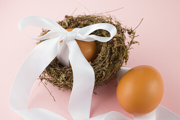 Easter concept, egg in a nest with a white ribbon. Happy Easter