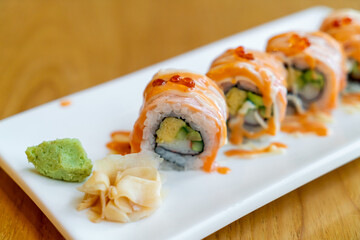 salmon roll sushi with sauce on top