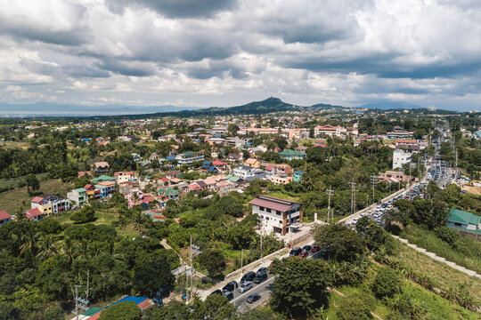 Aerial of residential houses in Tagaytay with People's Park in the Sky behind and Laguna Lake in the horizon.
