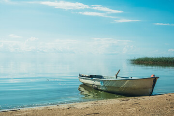 Obraz premium White wooden boat on the lake.