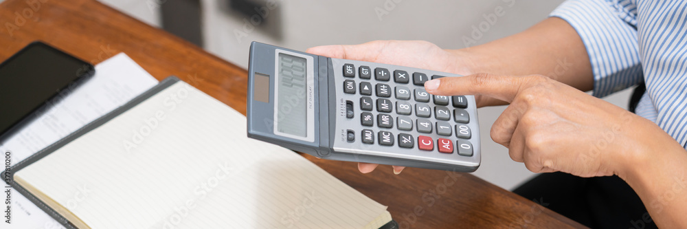 Poster concept of accounting work, business man doing paperwork using a calculator at the office and financ