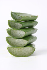 Aloe vera cut into pieces, stacked on a white background.